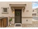 Townhome front door with wreath, small potted plant and light fixture at 7446 S 30Th Run, Phoenix, AZ 85042