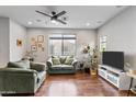 Bright living room with hardwood floors, comfy seating, and large TV at 7446 S 30Th Run, Phoenix, AZ 85042