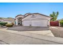 Three-car garage and front yard view of suburban home at 9821 E Obispo Ave, Mesa, AZ 85212