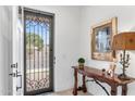 Inviting foyer featuring a decorative front door, elegant console table, and unique wall art at 1332 E Sierra Vista Dr, Phoenix, AZ 85014