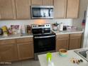 Bright kitchen with stainless steel appliances and light wood cabinets at 18225 W Yavapai St, Goodyear, AZ 85338