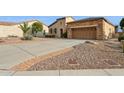 Front view of a charming home with a long driveway and desert landscaping at 28365 N 124Th Dr, Peoria, AZ 85383