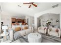 Bright living room features modern decor, ceiling fan, and flows into the kitchen and dining area at 33612 N 24Th Dr, Phoenix, AZ 85085