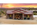 House exterior showcasing a patio, fire pit, and sunset view at 5063 E Reavis St, Apache Junction, AZ 85119