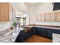 Bright kitchen features granite countertops, copper sink, and ample cabinet space, complemented by wooden floors and natural light at 5582 W Aster Dr, Glendale, AZ 85304