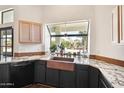 This bright kitchen features granite countertops, a copper sink, modern appliances, and a large window overlooking the backyard at 5582 W Aster Dr, Glendale, AZ 85304