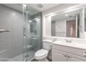 Updated bathroom with gray tile, a glass shower, and a white vanity at 600 S Dobson Rd # 166, Mesa, AZ 85202