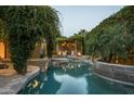 Beautiful backyard pool area featuring lush greenery, stone accents, and outdoor seating at 6529 E Camino De Los Ranchos St, Scottsdale, AZ 85254