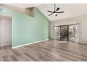 Bright living room with vaulted ceilings, wood-look floors, and sliding glass doors at 9127 W Kimberly Way, Peoria, AZ 85382