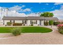 White brick ranch home with a lush green lawn at 980 Castillo E Dr, Litchfield Park, AZ 85340