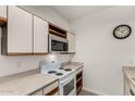 Kitchen with white appliances, wood cabinets, and a microwave at 1126 W Elliot Rd # 1058, Chandler, AZ 85224