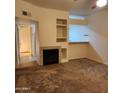 A cozy living room features a fireplace, built-in shelving, and neutral-toned carpeting at 1126 W Elliot Rd # 1058, Chandler, AZ 85224