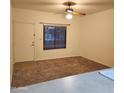 A bright living room features a ceiling fan, large window and neutral-toned carpeting at 1126 W Elliot Rd # 1058, Chandler, AZ 85224