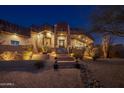 Luxury home exterior at night, showcasing architectural details and landscaping at 11501 E Mark Ln, Scottsdale, AZ 85262