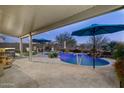 Relaxing pool area with patio cover and multiple umbrellas at 11971 E Chevelon Trl, Gold Canyon, AZ 85118