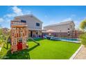 The backyard features a pool, playhouse, and green space, perfect for Gathering fun and outdoor enjoyment at 12378 W Roma Ave, Avondale, AZ 85392