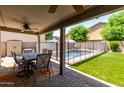 Inviting covered patio with ceiling fans, offering views of the backyard pool at 12378 W Roma Ave, Avondale, AZ 85392