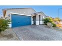 One-story house with blue garage door and brick driveway at 1523 S 223Rd Dr, Buckeye, AZ 85326