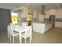 Kitchen with island, white cabinets, and dining area at 1628 E Magellan Dr, New River, AZ 85087