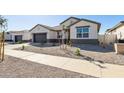 Modern house with neutral color scheme and desert landscaping at 25570 N 154Th Ln, Surprise, AZ 85387