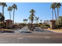 Gated community entrance with lush landscaping and palm trees at 3013 W Phelps Rd, Phoenix, AZ 85053