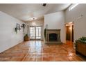 Living room with fireplace and terracotta tile floors at 3013 W Phelps Rd, Phoenix, AZ 85053