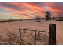 Large lot with chain link fence and desert landscape at sunset at 33767 W Grande Rd, Stanfield, AZ 85172