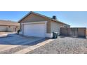 View of the house's side, showcasing the garage and a gated side yard at 5175 W Warren Dr, Casa Grande, AZ 85194