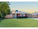 Front view of brick ranch house with carport and well-maintained lawn at 621 W Howe St, Tempe, AZ 85281