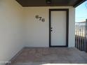 Front entrance with tiled flooring and a modern dark-framed door at 676 N 7Th Pl, Coolidge, AZ 85128