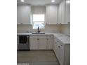 Modern kitchen boasts white shaker cabinets, quartz countertops, and stainless steel appliances at 676 N 7Th Pl, Coolidge, AZ 85128