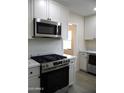 Stainless steel range, microwave, and white shaker cabinets in a newly remodeled kitchen at 676 N 7Th Pl, Coolidge, AZ 85128