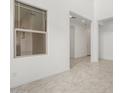 A living room with neutral tile floors, white walls, and a bright window at 7694 W Crabapple Dr, Peoria, AZ 85383