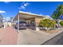 Manufactured home with covered parking and desert landscaping at 7750 E Broadway Rd # 684, Mesa, AZ 85208