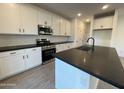 Modern kitchen with white cabinets, black countertops and island at 9346 E Sequence Ave, Mesa, AZ 85212