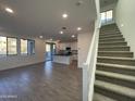 Open living room with kitchen island and modern staircase at 9346 E Sequence Ave, Mesa, AZ 85212