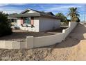 Side view of the home showcasing its light gray exterior and block wall at 9902 W Coggins Dr, Sun City, AZ 85351