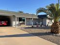 Single story home with a covered carport and well-manicured front yard at 9902 W Coggins Dr, Sun City, AZ 85351