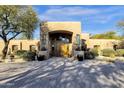 Inviting front entrance with an elegant wooden door, lush greenery, and a welcoming pathway at 9980 E Charter Oak Rd, Scottsdale, AZ 85260