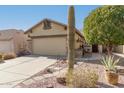 Tan house with stone accents, two-car garage, and desert landscaping at 11153 E New Frontier Ct, Gold Canyon, AZ 85118