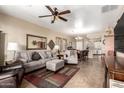Spacious living room with comfy seating, ceiling fan, and view to kitchen at 11153 E New Frontier Ct, Gold Canyon, AZ 85118