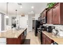Modern kitchen with granite countertops, black appliances, and ample storage at 14765 W Alexandria Way, Surprise, AZ 85379