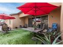 Relaxing covered patio with comfortable seating and a stylish red sun umbrella at 14765 W Alexandria Way, Surprise, AZ 85379