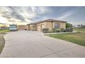 Beige stucco home with RV parking, three-car garage and long concrete driveway at 1716 S 141St Pl, Gilbert, AZ 85295