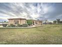 Single story stucco home with manicured lawn and desert landscaping in front yard at 1716 S 141St Pl, Gilbert, AZ 85295
