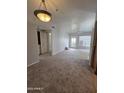 Spacious carpeted living room featuring a ceiling fan and a door to the outside at 1825 W Ray Rd # 2031, Chandler, AZ 85224