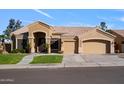 Inviting front of the house with a manicured lawn, arched entrance, and a spacious three-car garage at 1890 W Wisteria Dr, Chandler, AZ 85248