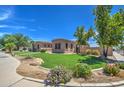 Well-maintained house with a lush green lawn and colorful flowers at 20971 S Hadrian Way, Queen Creek, AZ 85142