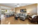 Bright living room with hardwood floors, gray sectional sofa and wood coffee table at 22454 N San Ramon Dr, Sun City West, AZ 85375