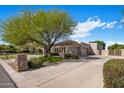 View of the house and attached garages from the street, surrounded by manicured shrubs and greenery at 300 N Portland Ave, Gilbert, AZ 85234